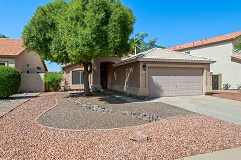 A house with a brown roof and a grey garage door.